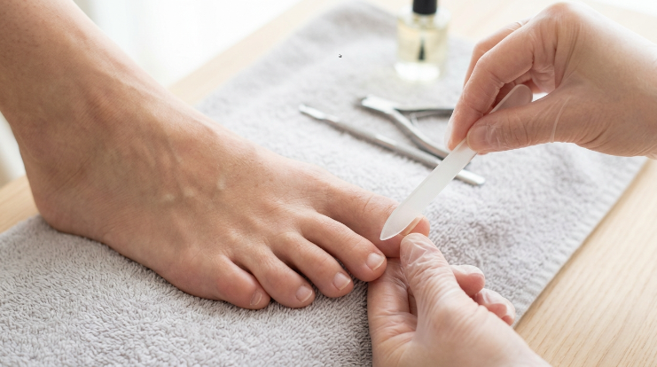Using a nail file safely on the edge of a lifting toenail