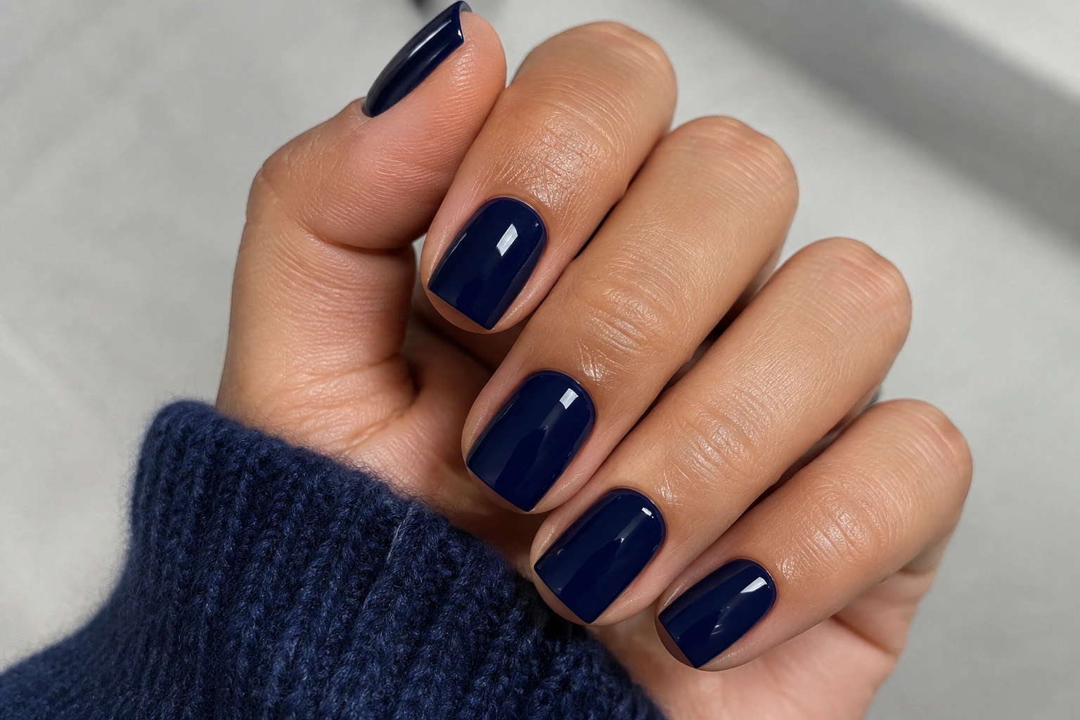 Glossy navy blue nails on a neat short square manicure