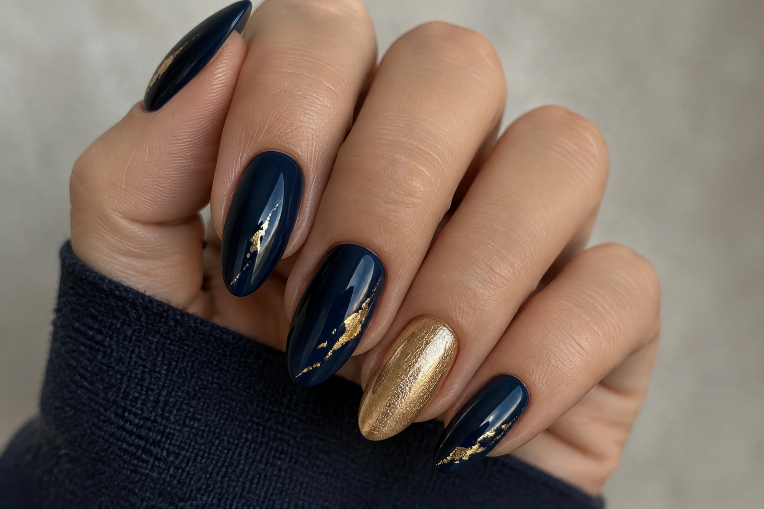 Navy blue nails with a single gold accent nail and thin foil detail