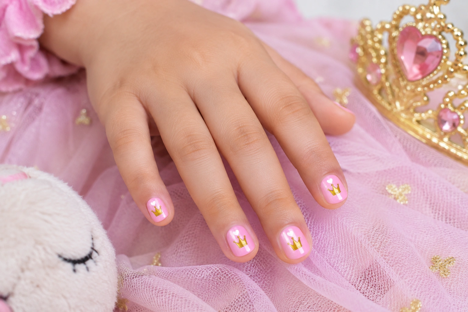 Child-friendly princess nails with pastel polish and crown stickers